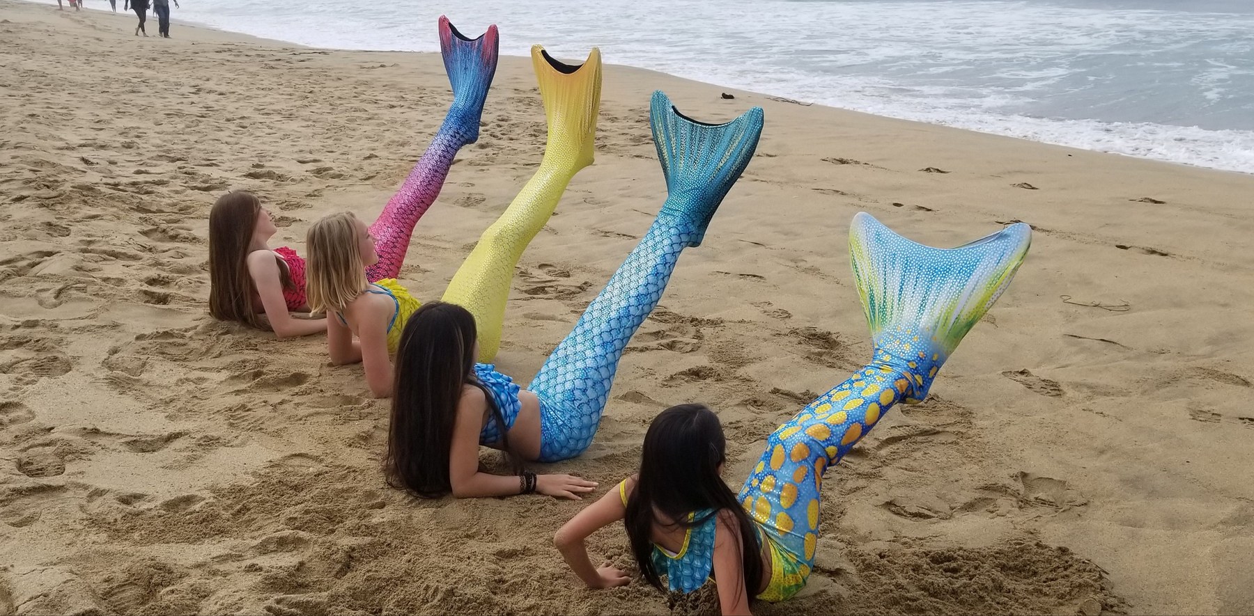 Lexinie Sport customers wearing colorful mermaid tails on the California beach